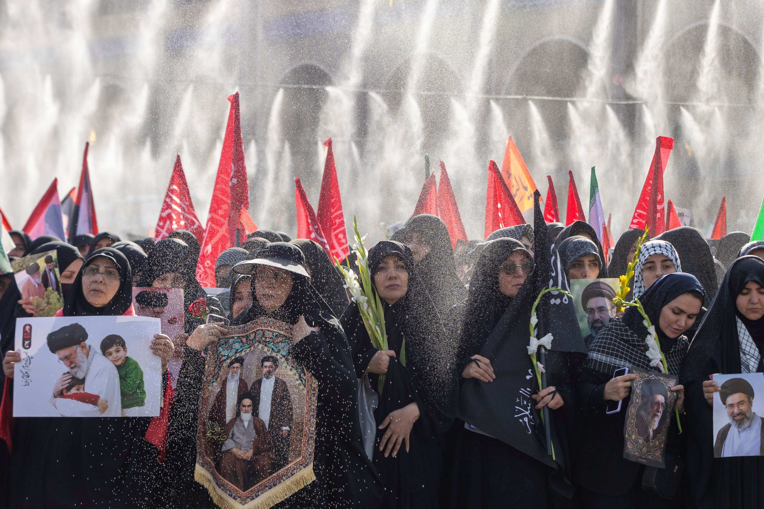 Celles qui se trouvent en tête de la procession brandissent des photos de l’ayatollah Khamenei, tandis que celles qui se trouvent à l'arrière brandissent des drapeaux. © Maryam Rahmanian/Shutterstock