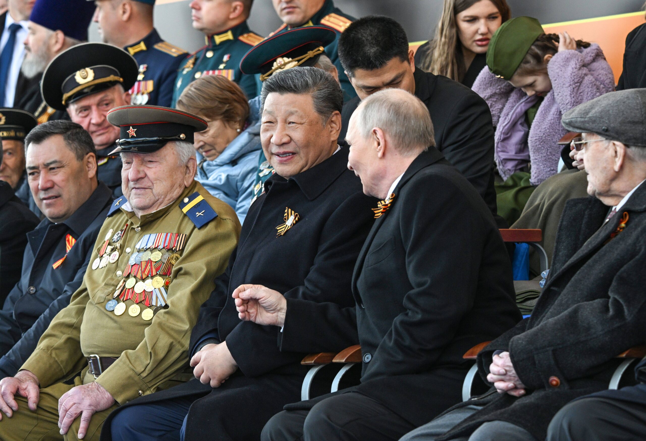 L'aparté souriant des deux dirigeants qui ont mis en scène leur proximité, ruban de Saint-Georges au revers, sous l'œil des officiels. Photo : Sergey Bobylev