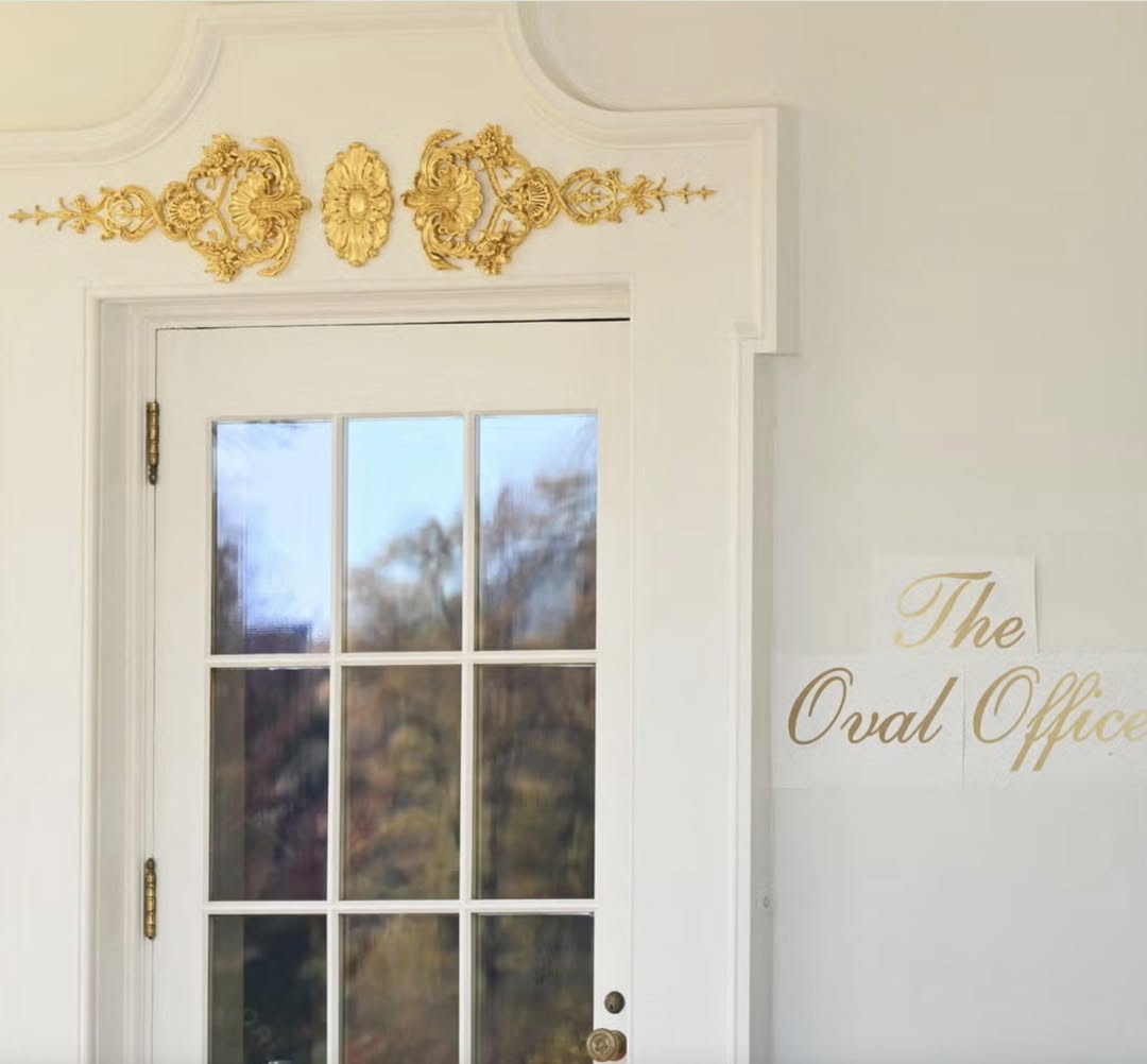 The Oval Office’s exterior door, beneath the colonnade, gilded rocaille embellishment above the frame and, on the wall, the inscription “The Oval Office” in gilded cursive letters — applied on sheets of paper whose edges still peel away from the wall. Official photo