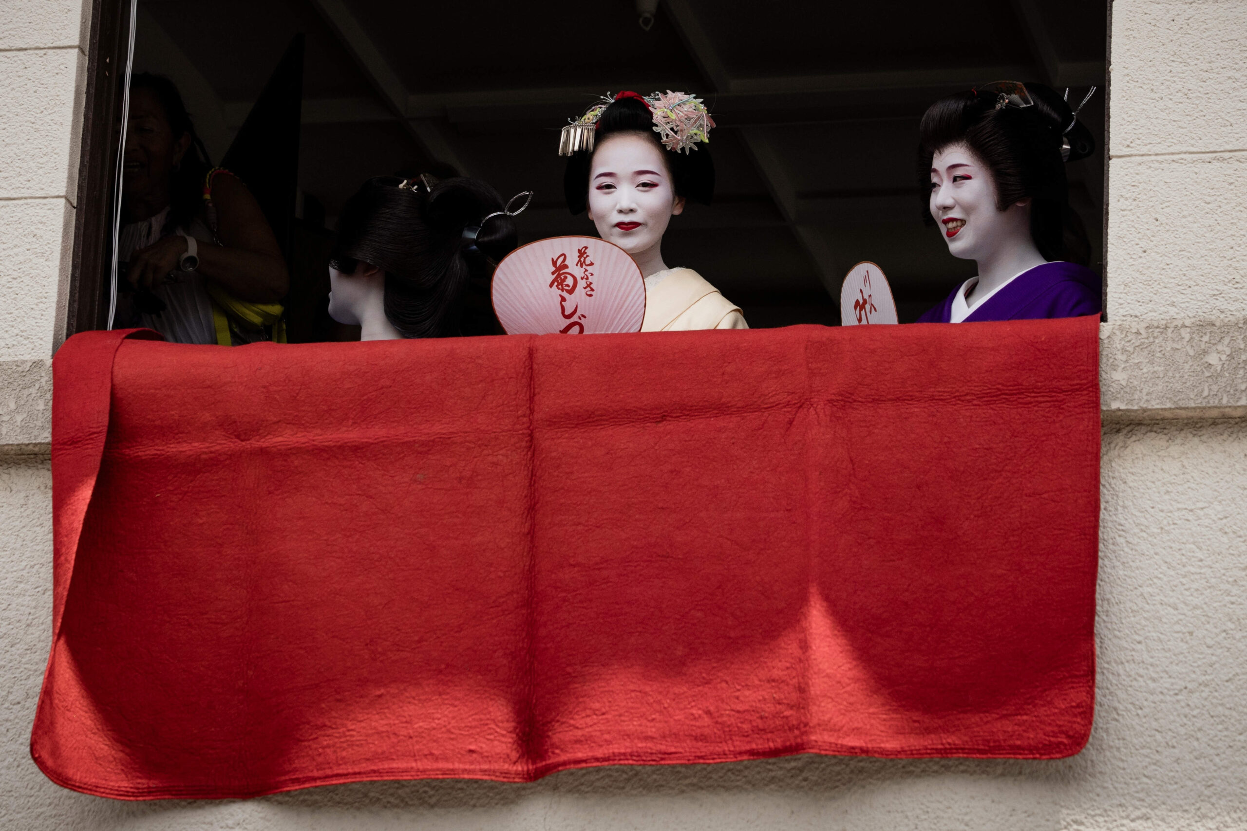 Une geiko (ou geisha) et une maiko regardent l'une des principales parades du festival Shinto Gion Matsuri à Kyoto.