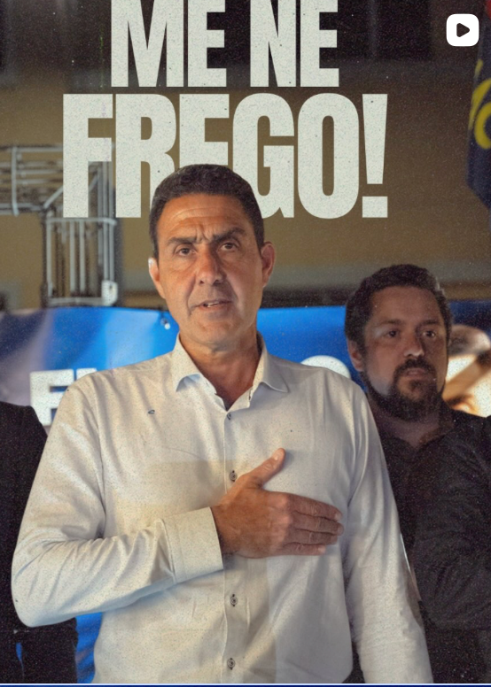 Screenshot of a video (play icon visible top-right) showing a Futuro Nazionale candidate, hand on heart, delivering Mussolini’s slogan 'Me ne frego!'