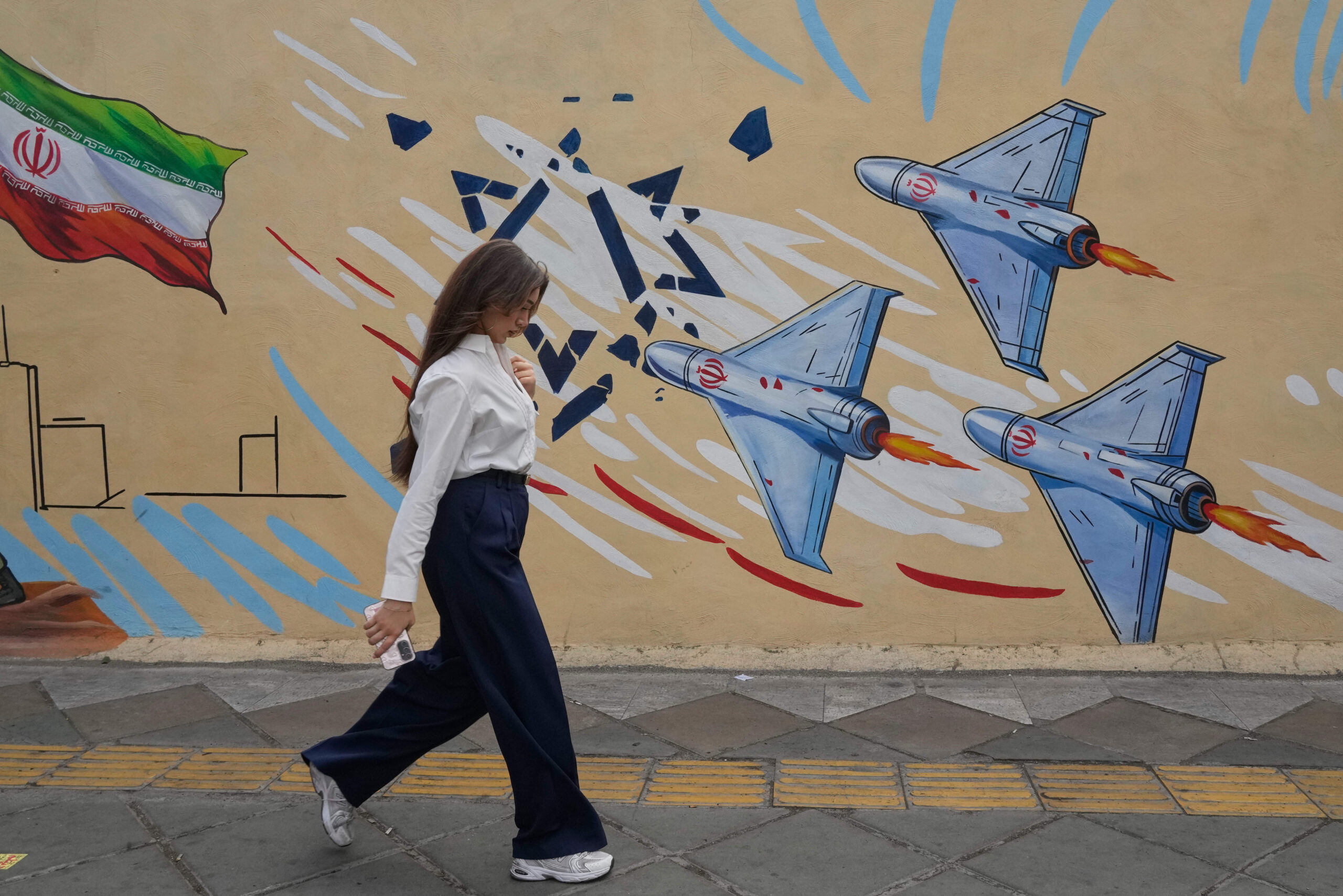 Une femme passe devant une fresque anti-Israël à Téhéran, en Iran, le 17 mai 2026.