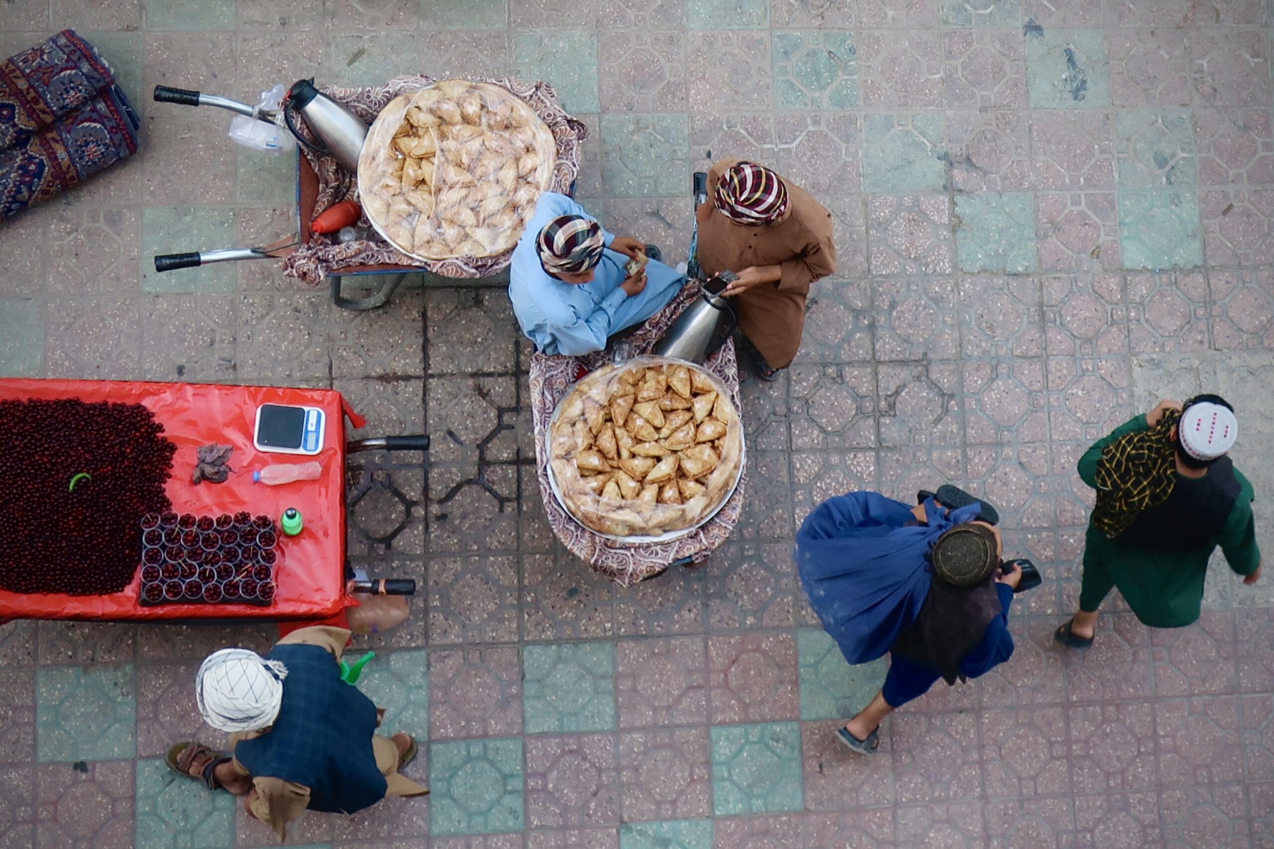 Vendeurs de cerises et de pâtisseries dans une rue de Mazar i Sharif. L'État taliban ne produit rien et ne fournit aucun service, mais il prélève partout, jusque sur les marchands ambulants. © Nicolò Sancassiani.