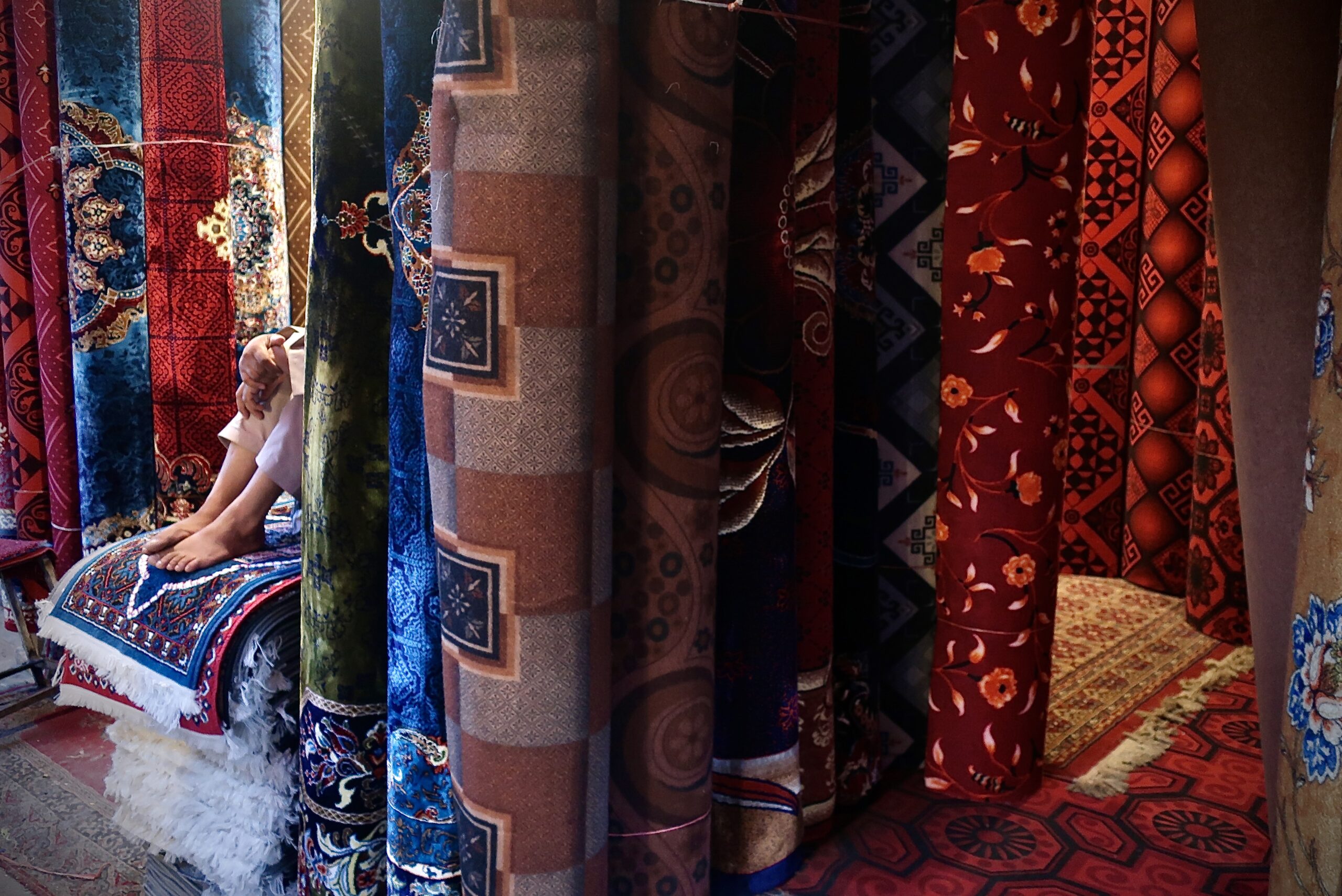 Tapis roulés dans un bazar. Avec les fruits secs et le safran, le tapis reste l'une des rares exportations légales du pays. © Nicolò Sancassiani.