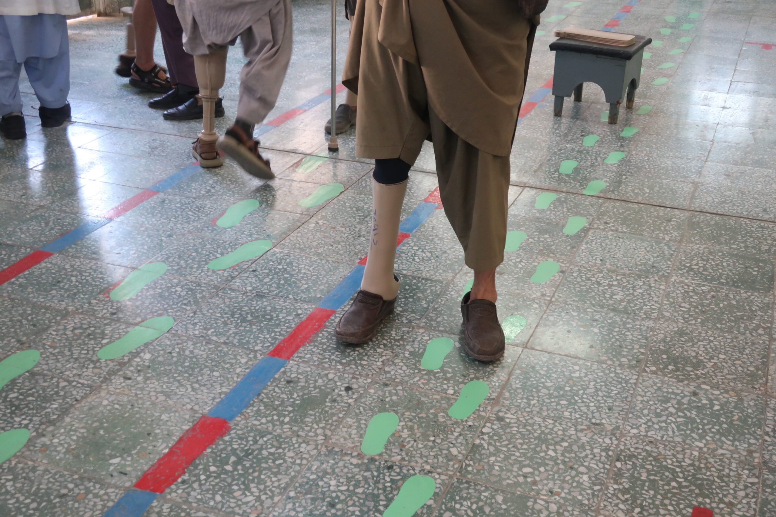 Salle de rééducation d'un centre orthopédique de Kaboul. Les empreintes peintes au sol guident les premiers pas des amputés appareillés. On compte environ 100 000 civils amputés en Afghanistan, pour plus de 15 millions de mines enfouies depuis 1979. © Nicolò Sancassiani.