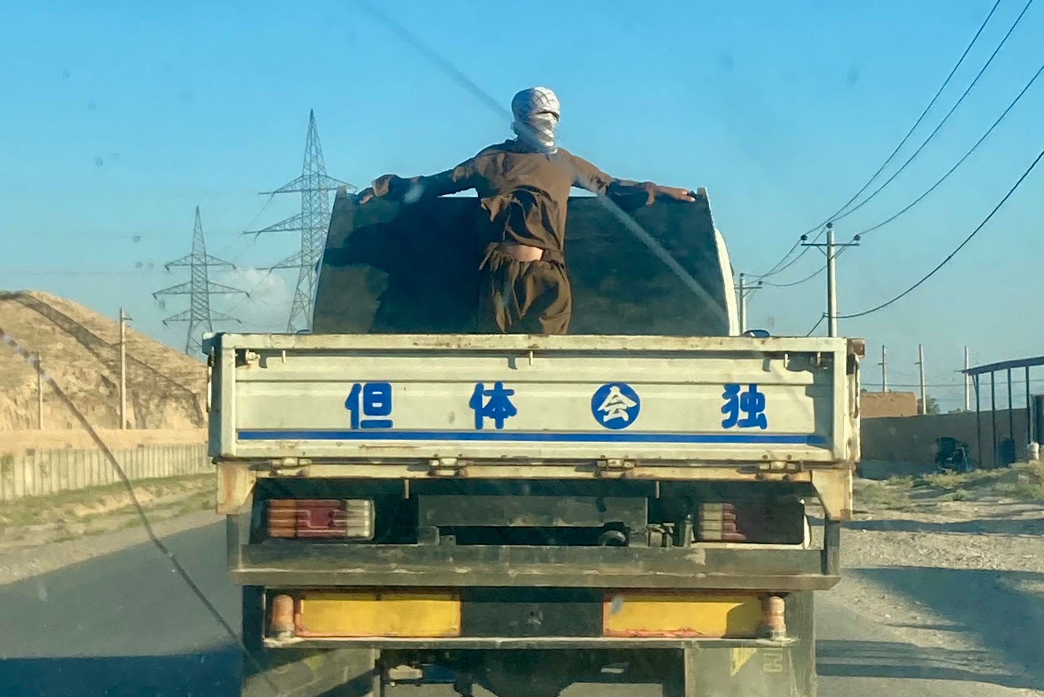 Un homme debout à l'arrière d'un camion d'importation asiatique. Véhicules et textiles chinois inondent les marchés de Kaboul à Herat © Nicolò Sancassiani.