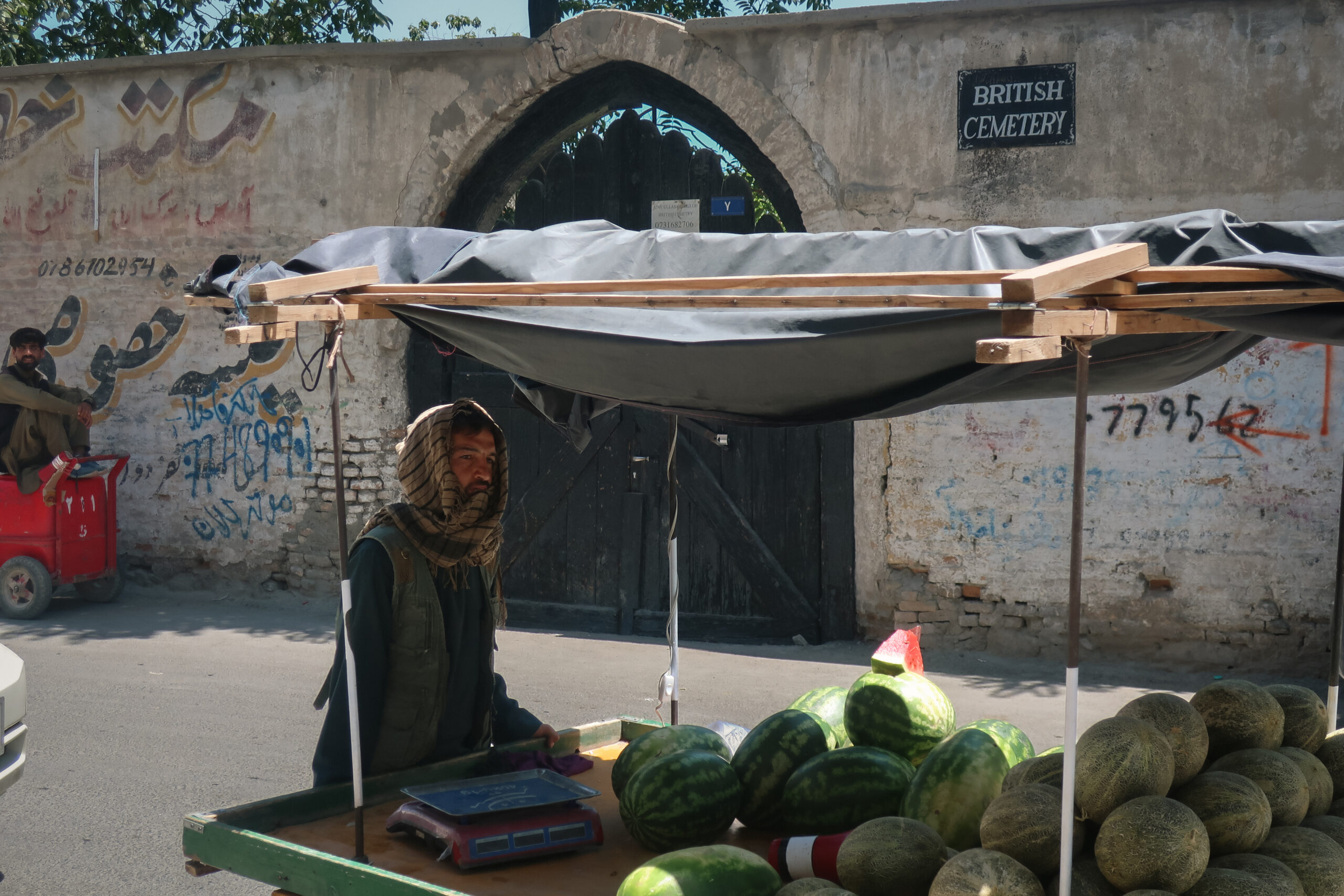 Un vendeur de pastèques devant le cimetière britannique de Kaboul, dans le quartier de Sherpur. Y reposent des soldats des trois guerres anglo-afghanes du XIXe siècle, puis des morts de l’OTAN. © Nicolò Sancassiani.