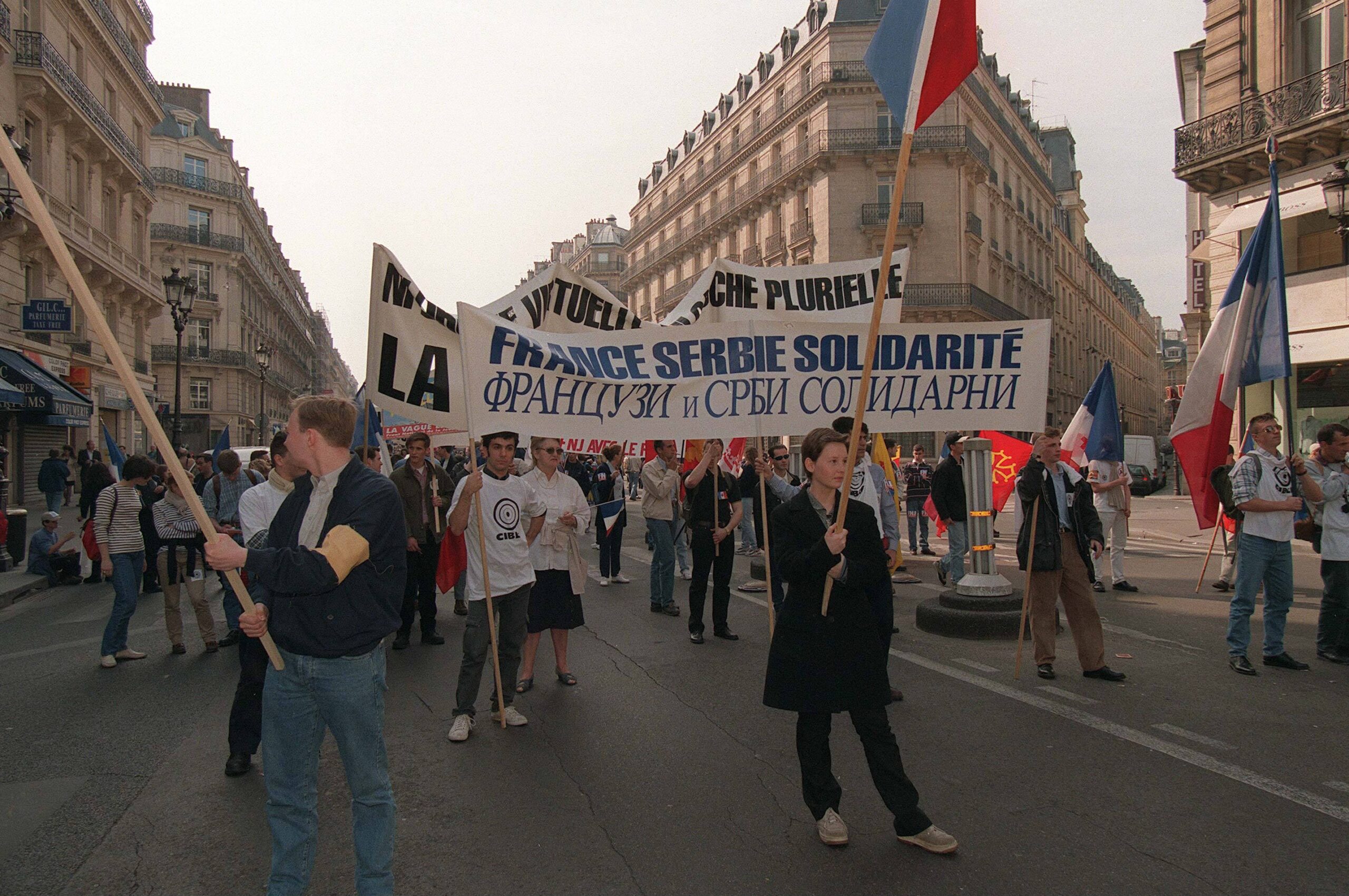 Parade of the Front National on May 1, 1999 in Paris, displaying banners 'France Serbia Solidarity'.